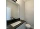 An elegant powder room with a dark countertop, modern sink, and minimalist design at 498 Traditions Grande Blvd # 23, Wake Forest, NC 27587