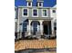 Charming gray two-story home boasts a welcoming front porch and elegant black wrought iron fence at 498 Traditions Grande Blvd # 23, Wake Forest, NC 27587