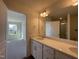 Bathroom featuring granite countertops with double sinks, a large mirror, and an adjacent bedroom at 500 Traditions Grande Blvd # 22, Wake Forest, NC 27587