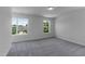 A well lit bedroom with neutral colored carpet with views to the trees and neighborhood at 500 Traditions Grande Blvd # 22, Wake Forest, NC 27587