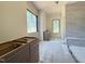 Unfinished bathroom featuring double vanity, a window, and tiled walls at 7013 Buckhead Dr, Raleigh, NC 27615