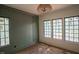 Light-filled bedroom with large windows, elegant light fixture, and a modern accent wall at 7013 Buckhead Dr, Raleigh, NC 27615