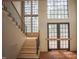 Two-story entryway boasts a staircase with black metal railing and views of the front yard through large windows at 7013 Buckhead Dr, Raleigh, NC 27615