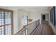 Hallway features large windows that flood the space with natural light, complemented by modern railing at 7013 Buckhead Dr, Raleigh, NC 27615