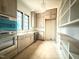 Bright open kitchen with stainless steel appliances, gray cabinets, and custom open shelving at 7013 Buckhead Dr, Raleigh, NC 27615