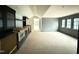 Living area featuring a wet bar, dark cabinetry and large windows offering backyard views at 7013 Buckhead Dr, Raleigh, NC 27615