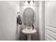 Small powder room with pedestal sink and oval mirror at 891 Cupola Dr, Raleigh, NC 27603