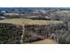 Aerial view of land with a mix of trees, fields, and a road at 1100 Ben Smith Road Rd, Siler City, NC 27344