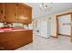 Retro kitchen with wood cabinets, red countertops, and white appliances at 1100 Ben Smith Road Rd, Siler City, NC 27344