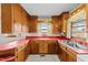 L-shaped kitchen with wood cabinets and red countertops at 1100 Ben Smith Road Rd, Siler City, NC 27344