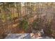 A high angle shot showing a roof top surrounded by a dense forest at 1210 Huntsman Dr, Durham, NC 27713