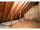 Open unfinished attic showcases wooden beams and insulation, offering potential for renovation and added living space at 1210 Huntsman Dr, Durham, NC 27713