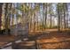 Wooded lot features a weathered shed with stone pathway, blending into the natural surroundings at 1210 Huntsman Dr, Durham, NC 27713