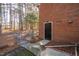 Side view of yard leading to a backyard gate adjacent to back door of brick house at 1210 Huntsman Dr, Durham, NC 27713