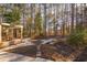 A wooden deck sits off the home with a gravel path and wooden bridge meandering to the back of the large yard at 1210 Huntsman Dr, Durham, NC 27713