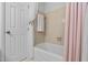 Bathroom featuring a tub with shower, tile surround, and a towel rack, offering a functional and clean space at 1210 Huntsman Dr, Durham, NC 27713