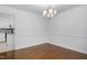 Elegant dining room with hardwood floors, a modern chandelier, and a view into the updated kitchen at 1210 Huntsman Dr, Durham, NC 27713