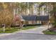 Charming brick home featuring a well-manicured lawn and a long driveway leading to a side garage at 1210 Huntsman Dr, Durham, NC 27713