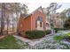 Charming brick home showcasing classic architecture, complemented by lush greenery and mature trees at 1210 Huntsman Dr, Durham, NC 27713