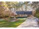 Well-maintained brick house with a manicured lawn and a long driveway leading to a side garage at 1210 Huntsman Dr, Durham, NC 27713
