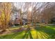A brick home with a well manicured lawn is viewed through budding trees at 1210 Huntsman Dr, Durham, NC 27713