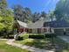 Charming brick home with well-maintained landscaping, sidewalk, and attached garage at 1210 Huntsman Dr, Durham, NC 27713