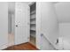 Hallway with wooden floors, a stairwell, and a linen closet with shelving for storage at 1210 Huntsman Dr, Durham, NC 27713