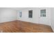 Well-lit room with wood floors, white walls, and large windows at 1210 Huntsman Dr, Durham, NC 27713