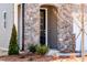 Close-up of a home entrance with a stylish black door and elegant stone accents at 213 Little Crk Dr, Lillington, NC 27546