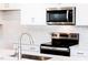 Sleek kitchen with stainless steel appliances, white cabinetry, and marble backsplash at 213 Little Crk Dr, Lillington, NC 27546