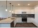 Modern kitchen with granite countertops, stainless steel appliances, and white shaker cabinets at 2206 Gathering Sq Ct # 2206, Fuquay Varina, NC 27526