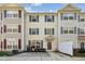 Three-story townhome with neutral siding, shutters, and a paved patio at 2225 Raven Rd # 107, Raleigh, NC 27614