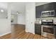 Kitchen with stainless steel appliances and dark cabinets, overlooking living room at 2225 Raven Rd # 107, Raleigh, NC 27614