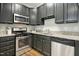 Kitchen with dark cabinets, granite countertops, and stainless steel appliances at 2225 Raven Rd # 107, Raleigh, NC 27614