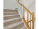 Carpeted staircase with wooden railing and banister at 2225 Raven Rd # 107, Raleigh, NC 27614