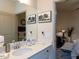 Bright bathroom vanity with large mirror, modern fixtures, and a glimpse of the bedroom at 2313 Gathering Square Ct # 2313, Fuquay Varina, NC 27526