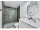 Spa-like bathroom with green tile shower, marble vanity, and modern fixtures at 406 Everette Ave, Clayton, NC 27520