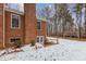Side view of a brick house with a walkout basement and snow-covered yard at 4139 Somerset Dr, Oxford, NC 27565