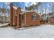 Rear exterior of brick home with large deck, chimney, and mature trees at 4139 Somerset Dr, Oxford, NC 27565