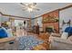 Open-concept living room with a brick fireplace, wood floors, and french doors at 4139 Somerset Dr, Oxford, NC 27565