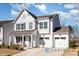 Two-story white house with two-car garage, stone accents, and a front yard at 440 Curling Creek Dr, Clayton, NC 27527