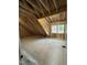 Unfinished attic space shows exposed beams and construction materials, with a window at 504 Tucker St, Four Oaks, NC 27524