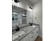 Modern bathroom features a double vanity with granite countertop, framed mirror, and sleek black fixtures at 504 Tucker St, Four Oaks, NC 27524