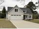 Front exterior view of gray home with dormer windows and a two-car garage at 504 Tucker St, Four Oaks, NC 27524