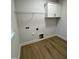 Clean laundry room with cabinet, shelving and vinyl flooring at 504 Tucker St, Four Oaks, NC 27524
