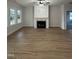 Cozy living room with a fireplace, hardwood floors, and large windows at 504 Tucker St, Four Oaks, NC 27524