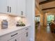 Butlers pantry with white cabinets, quartz countertops, and open shelving at 64 W Beech Slope Ct, Chapel Hill, NC 27517