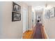 Long hallway with hardwood floors and framed Gathering photos at 715 Powell Dr, Raleigh, NC 27606