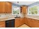 Kitchen features granite countertops, wood cabinets, and black appliances at 715 Powell Dr, Raleigh, NC 27606