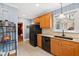 Galley kitchen with granite countertops, black appliances, and wood cabinets at 715 Powell Dr, Raleigh, NC 27606